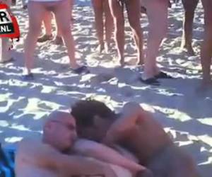 en sex trekant af en kvinde og to mænd er i fuld sving på en strand. men brune nogle mennesker bliver ikke. en kreds af voyeurs er at kigge og trække ud og tage fuckers alle solen.