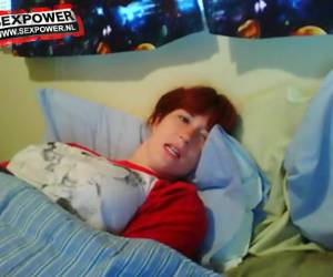 Dit is het ultieme gluren: ze masturbeert onder de dekens en met haar kleren aan.