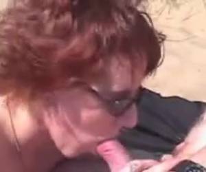 Pelirroja mamando polla en la playa